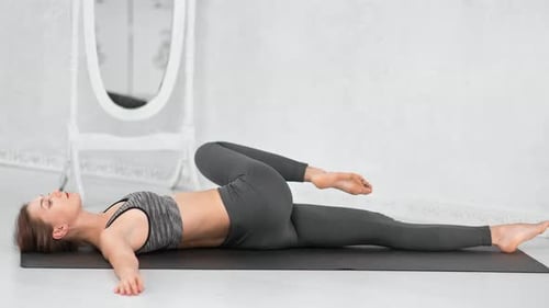 Young Woman Doing Yoga Spinal Twist Exercise