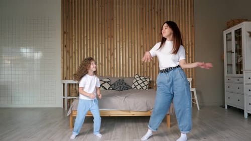 Cheerful Woman and Child Dancing Together at Home
