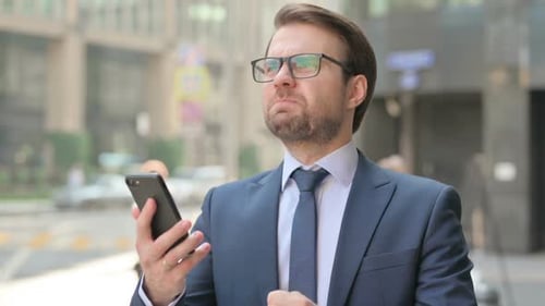 Man in Suit Reacts Angrily to Smartphone in City