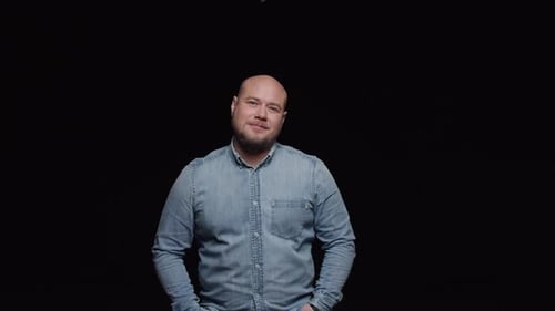 Man Smiling in Studio with Black Background