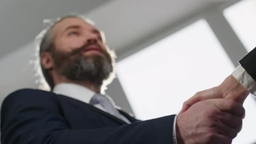 Man and Woman Shaking Hands in Business Center