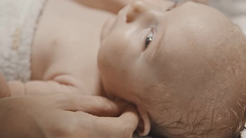 Loving Hand Cares for Newborn Baby Close-Up