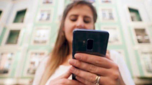 Woman Using Phone in Urban Environment