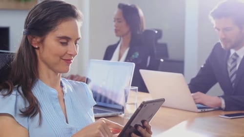 Woman Smiling Using Tablet in a Modern Office
