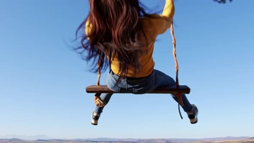 Vue d'une femme en été sur une balançoire