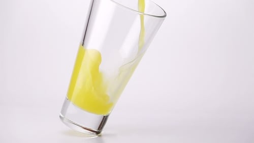 Yellow Liquid Being Poured Into a Glass