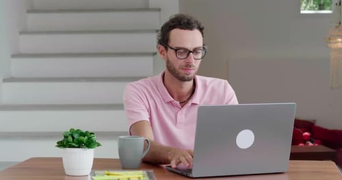 Young Man Working on Laptop in Home Office