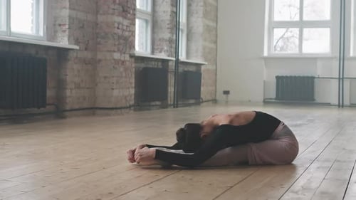 Ballerina Stretching in Bright Dance Studio