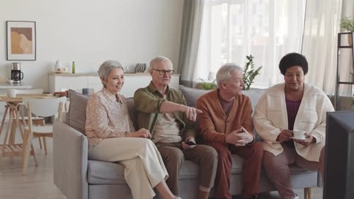 Mature Adults Watching Television Together on Couch