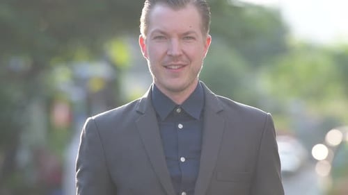 Smiling Man in Gray Suit Jacket on Street