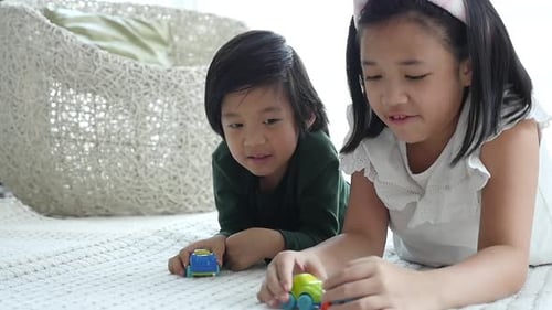 Children Play Together with Toy Cars on Rug