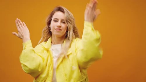 Woman Professional Dancer Dancing in Studio Against Yellow Background