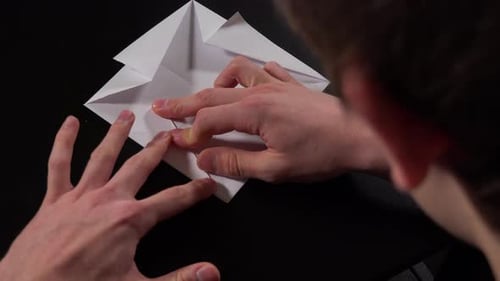 Hands Expertly Folding White Paper Origami