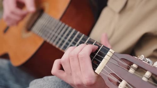 Cropped View of Male Hands Performing Song on Guitar