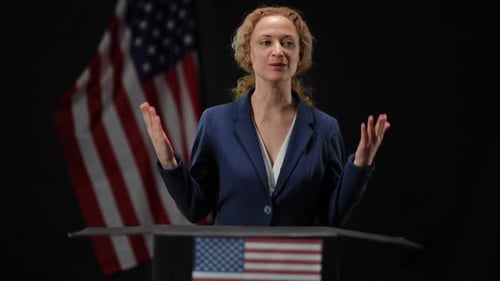 Woman Speaking at Podium With American Flag