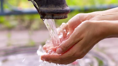 Water pours onto your hands. Environment concept. Conservation of natural resources.