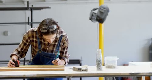 Female Welder Measuring a Wooden Plank 4k