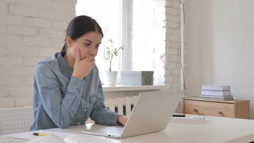 Woman Using Laptop Looks Concerned Indoors