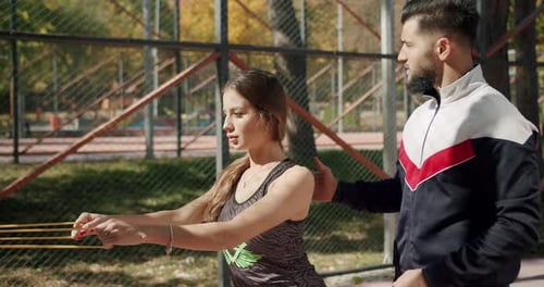 Woman Exercising With Resistance Band and Trainer