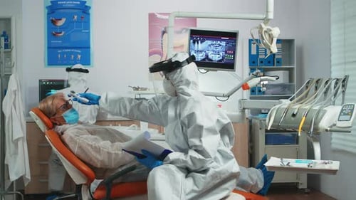 Dentist and Patient Wearing PPE in Modern Office