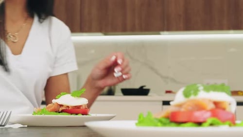 Woman prepares Salmon and Poached Egg Sandwich