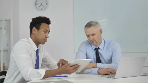Businessmen Discussing Data in Office with Laptop Tablet