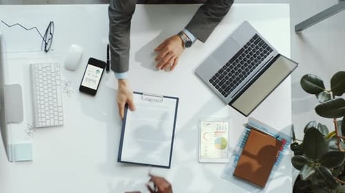 Signing Business Contract at Desk with Technology