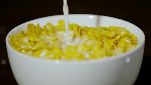 Milk Pouring on Flakes in White Bowl