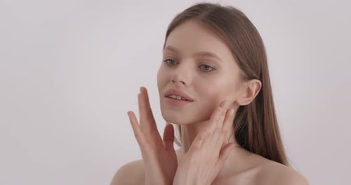 Woman Touches Her Face in a Gentle Close-Up