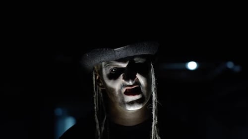 Creepy Man with Skeleton Makeup Appearing From Darkness When Light Falls on Him, Making Faces