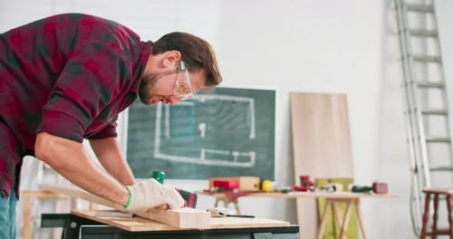 Carpenter Smoothing Wood with Hand Plane in Workshop