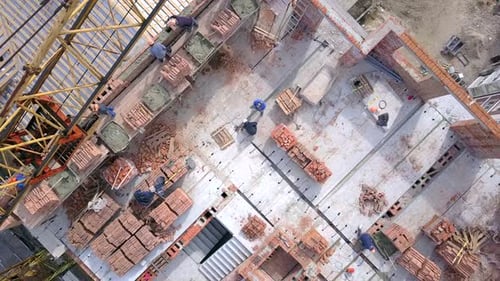 Construction workers working on a building site of new residential building.