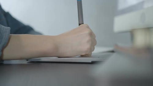 Hand Using a Digital Pen on a Tablet