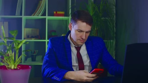 Empresario reflexivo que usa el teléfono móvil en un lugar de trabajo moderno