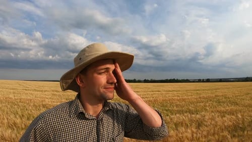 Close Up to Young Agronomist Standing on Barley Meadow and Looking at Cereal Plantation