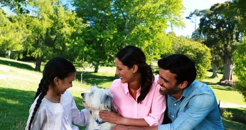 Family enjoying together with their pet dog in park