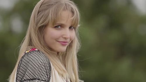 Young Woman Smiles Gently Outdoors