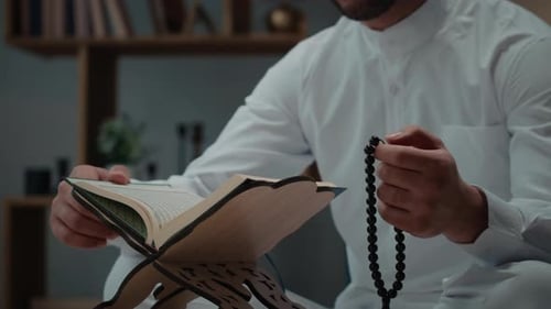 Man Reading Religious Book with Prayer Beads