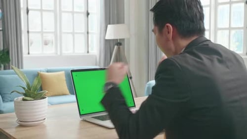 Successful Asian Businessman With Green Screen Computer While Working At Home