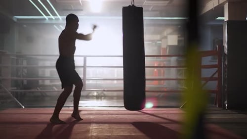 Kickboxing, Athletic Man Fighter Trains His Punches, Beats a Punching Bag, Training Day