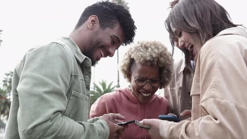 Friends Laughing Together Looking at Smartphones
