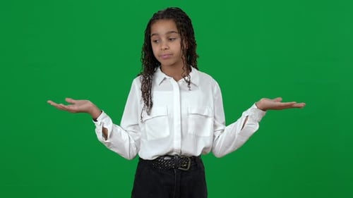 Unsure Puzzled African American Teen Girl Holding Invisible on Green Screen Shrugging Shoulders