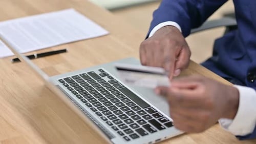 Online Shopping on Laptop By African Businessman