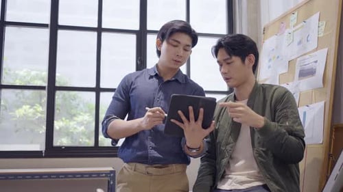 Young Men Brainstorming Business Plan in Office