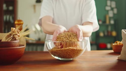 Person Prepares Grain Bowl in Sunny Kitchen