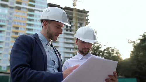 Construction engineers look at building plans