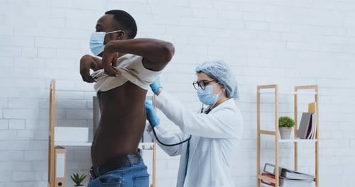 Doctor Listens to Patient's Heart with Stethoscope