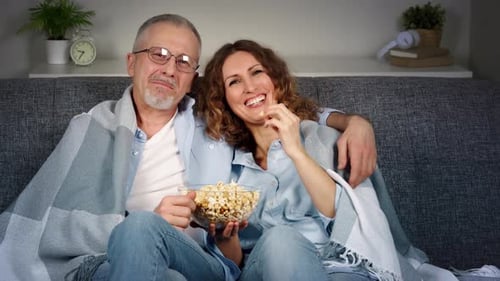 Couple Relaxing on Couch Eating Popcorn
