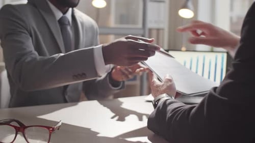 Two Multiethnic Businessmen Signing Contract in Office