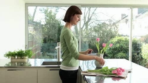 Woman Arranges Tulips in Modern Kitchen